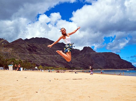 Stagista felice che corre sulla spiaggia di Las Teresitas