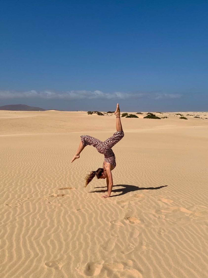 Intern doing a handstand on the beach