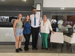 Two interns taking a photo with two collegues during hotel internship abroad.