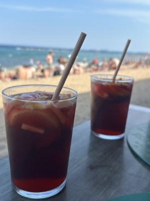 Relaxing with a refreshing glass of sangria on the beach, unwinding after a productive day.