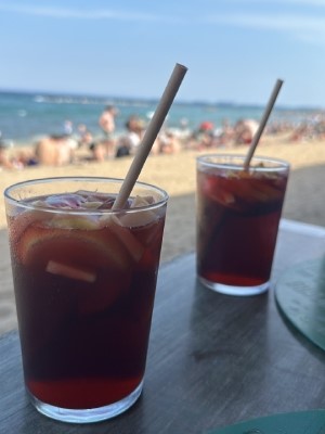 Rilassandosi con un bicchiere di sangria fredda sulla spiaggia, dopo una giornata di lavoro.