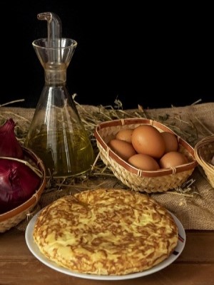 Ein Hotelpraktikant genießt eine traditionelle spanische Tortilla in einem lokalen Restaurant während seines Praktikums in Spanien.